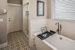 Master bath with soaking tub and a beautifully tiled shower.